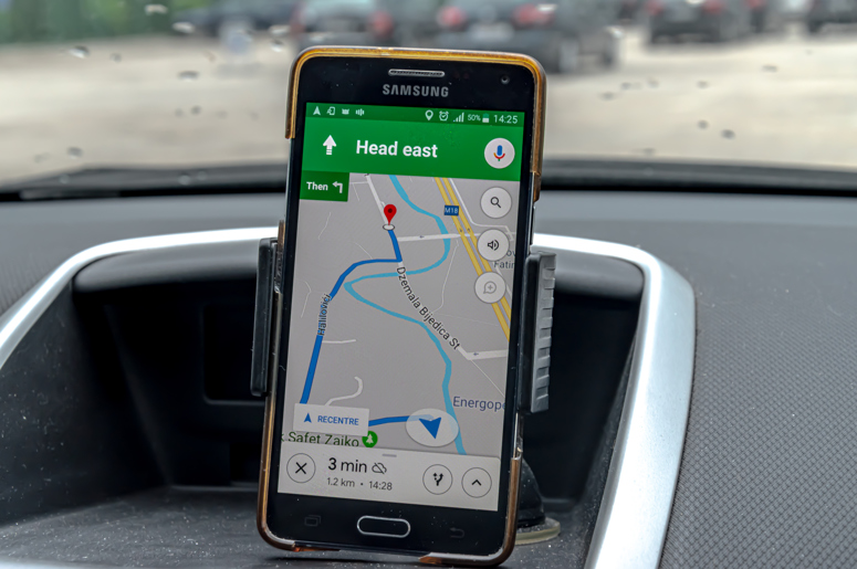 iPhone in a car mount with Google Maps on the screen
